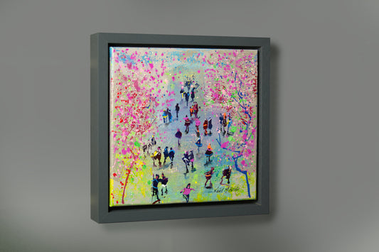 Framed abstract artwork with colourful splashes of blossom pink and a crowd of people on a grey wall