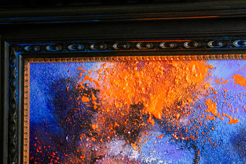 Detail of the hand tinted frame surrounding McBride's Flame Tree landscape painting